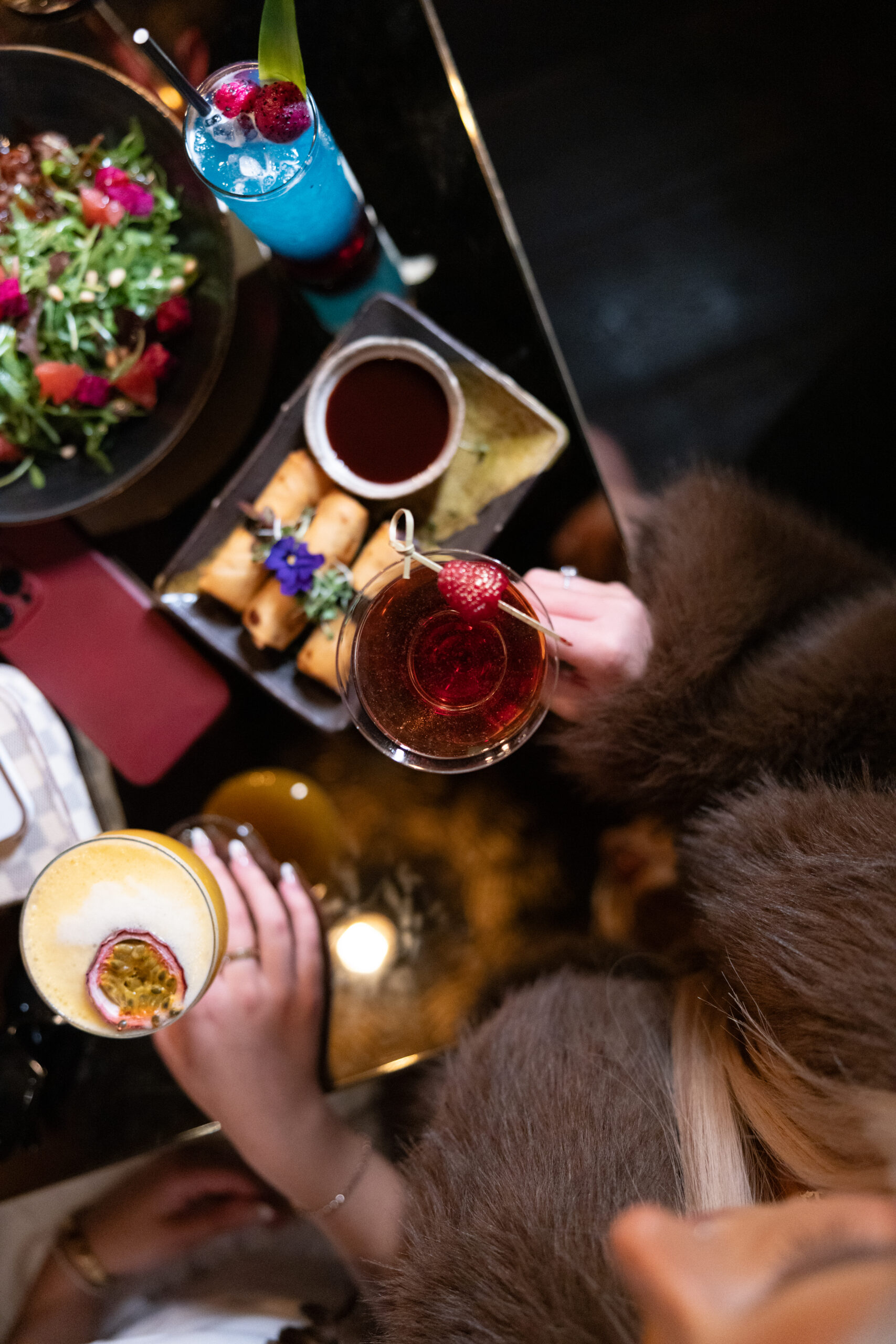 A group sharing dim sum, spring rolls and cocktails at Lulu Wild, Birmingham